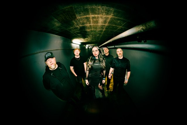 The band together in a dim backstage corridor