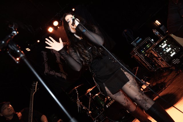 Sarah singing with an open hand toward the room