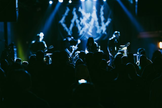 The audience silhouetted against blue stage lights