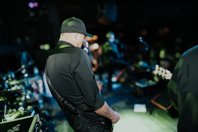 A guitarist facing the drum kit during the set