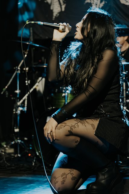Sarah singing beside a guitarist