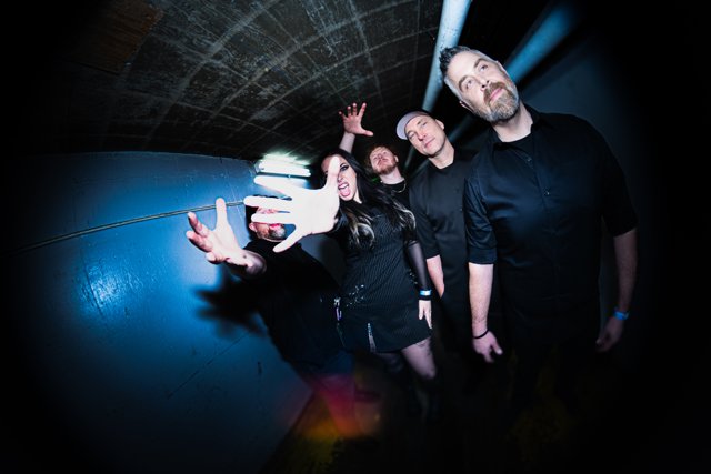 Band members posing with hand gestures backstage