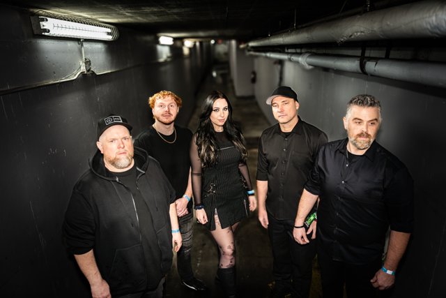 The band posing together in the backstage corridor