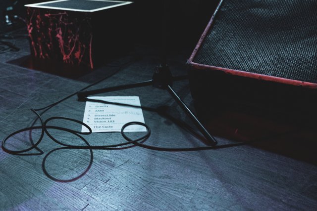 Cables and a set list on the stage floor
