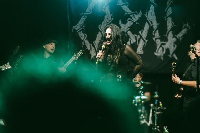 The band performing through green stage haze