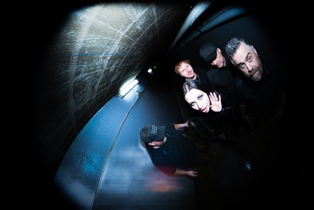 The band posing in a blue-lit corridor