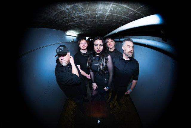 The band posing beneath blue corridor lights