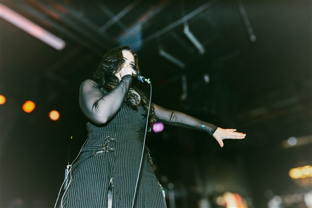 Sarah extending her arm toward the room during the performance