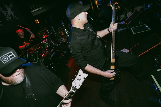 A guitarist performing beside the drummer