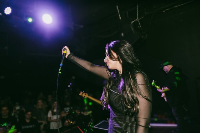 Sarah extending the microphone toward the audience
