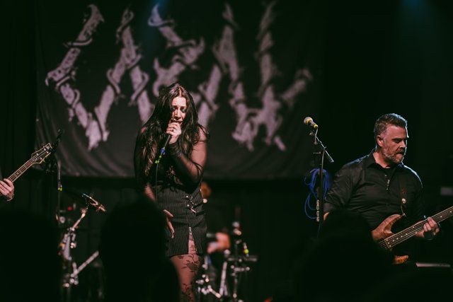Sarah and a guitarist performing in green light