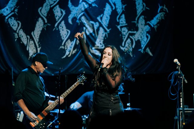 Sarah singing with one hand raised