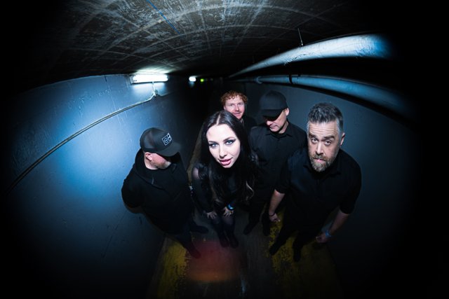 Band members leaning toward the camera in the corridor