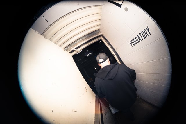 A band member beside a venue corridor door