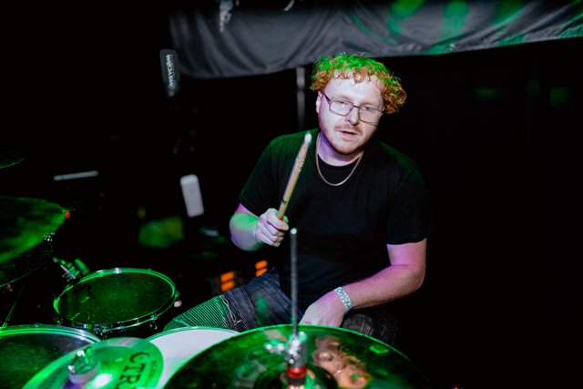 The drummer smiling behind the kit