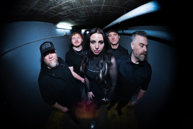 The band posing together in the blue-lit corridor