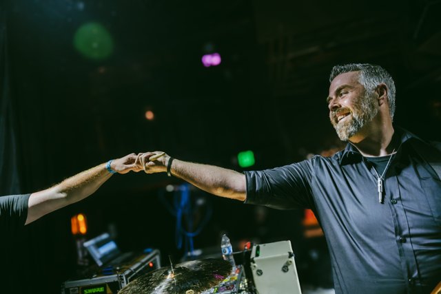 A guitarist reaching toward a hand from the crowd