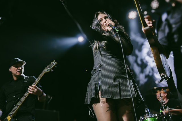 Sarah raising one arm while singing