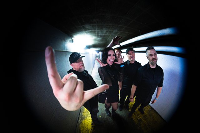 The band posing with a hand gesture close to the camera