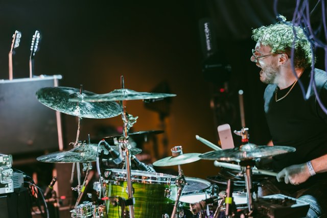 The drummer playing behind his cymbals