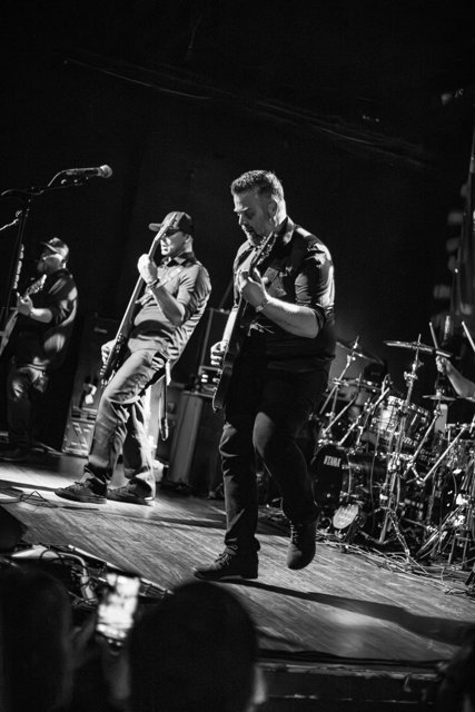 Sarah and a guitarist performing in black and white