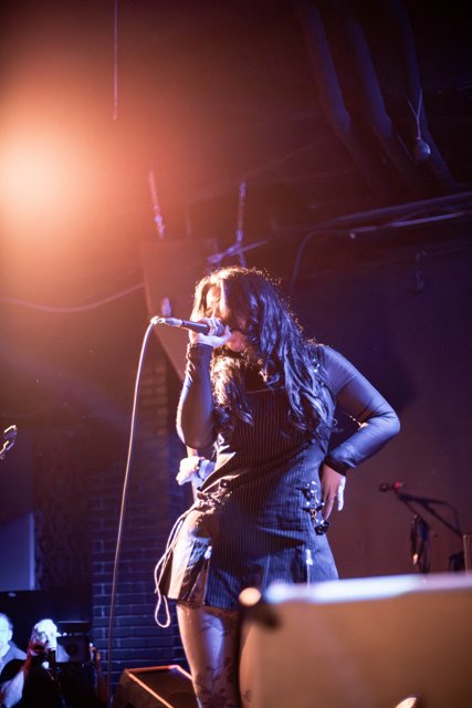 Sarah singing beneath amber stage lights