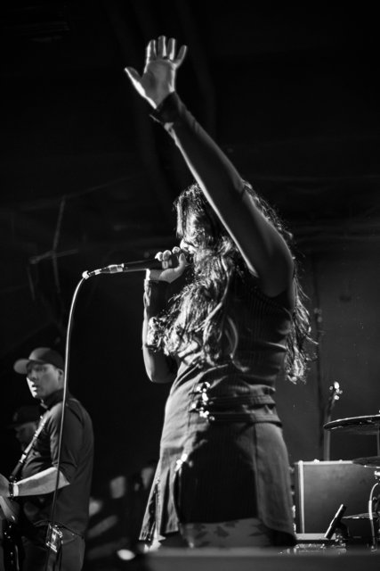 Sarah raising one hand in black and white