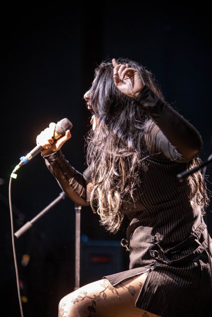Sarah crouching beside the microphone stand