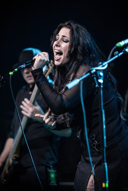 Sarah singing with an open hand near her chest