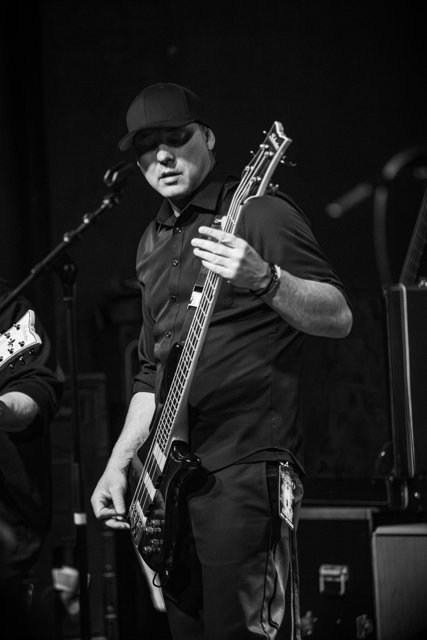 A guitarist performing in black and white