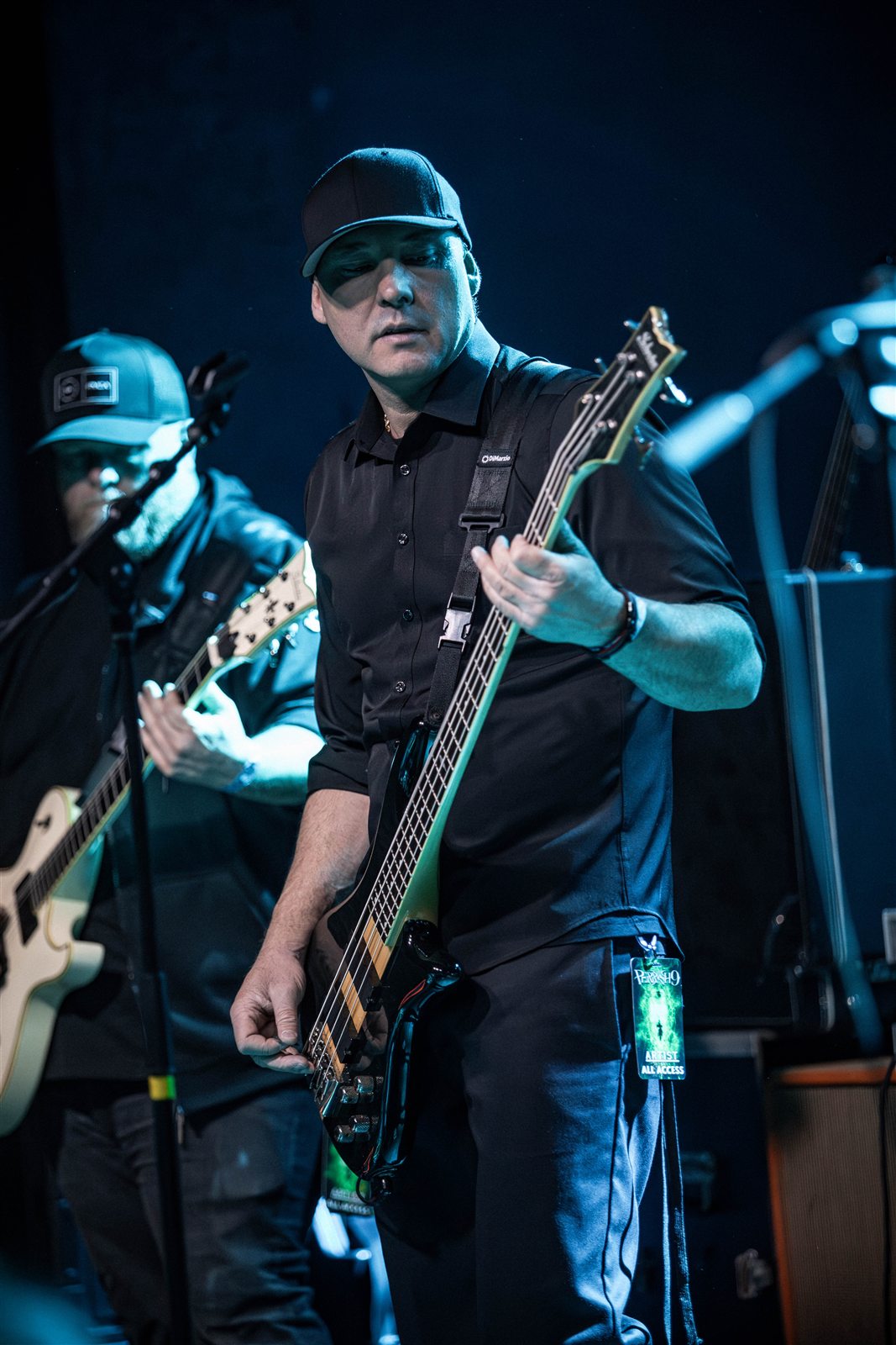 A guitarist playing with the band behind him