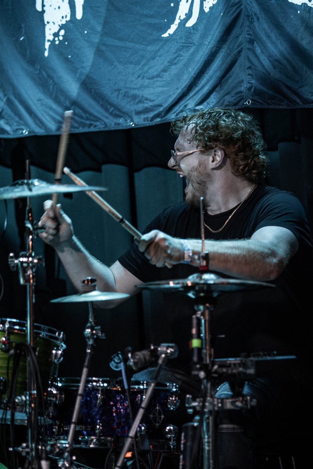 The drummer in motion behind the cymbals