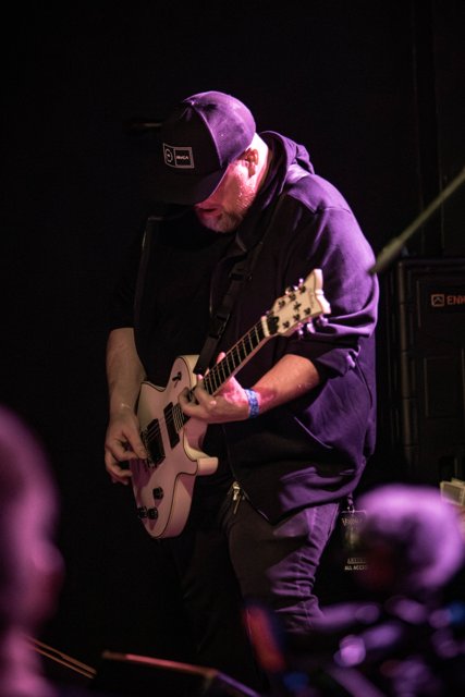 A guitarist looking down at his instrument