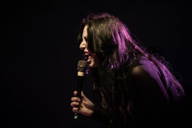 A close view of Sarah leaning toward the audience