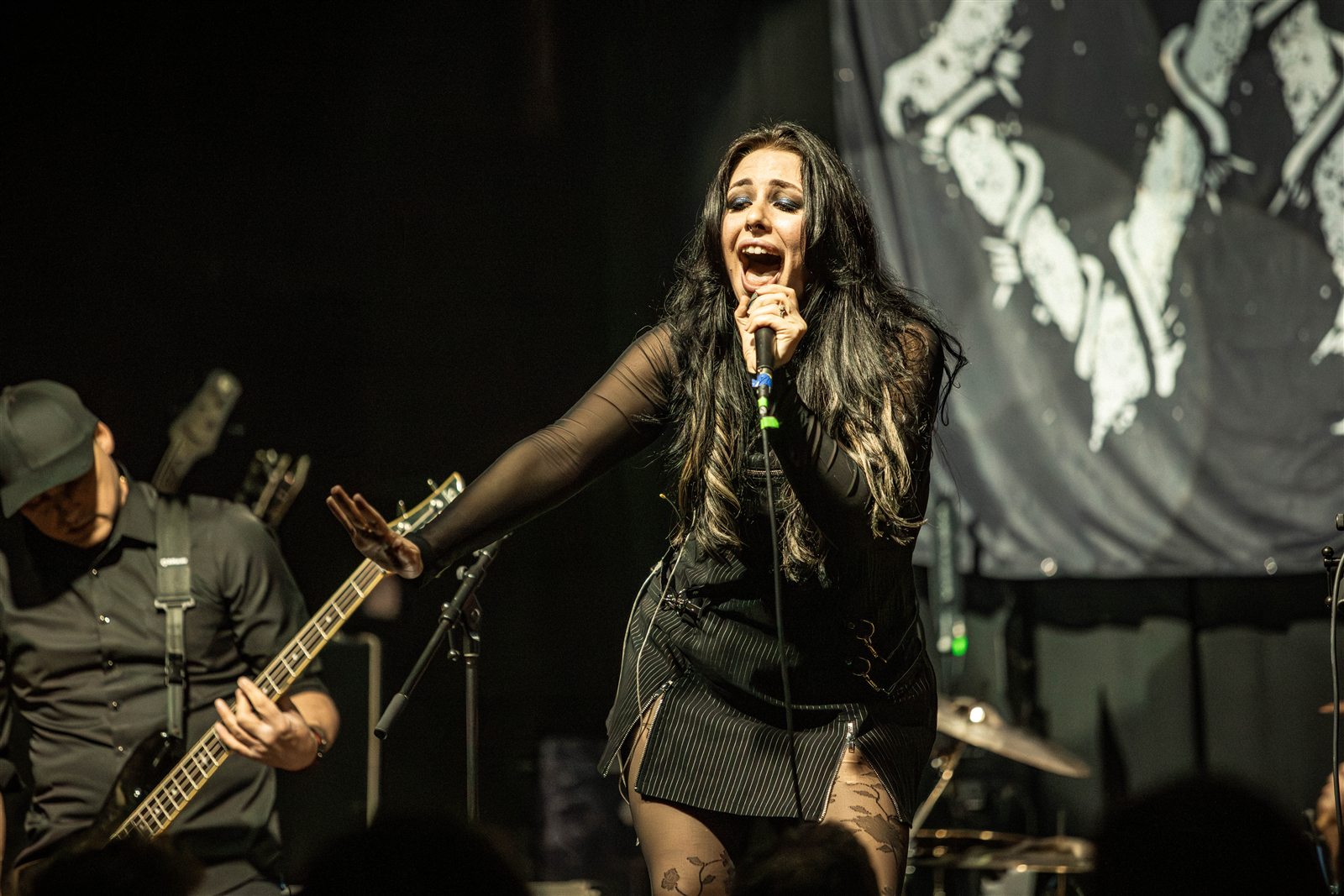Sarah reaching toward the audience with the guitarist beside her